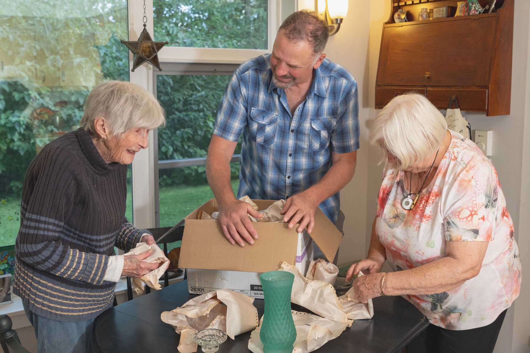 Decluttering: a provider helping two clients unpack and sort
