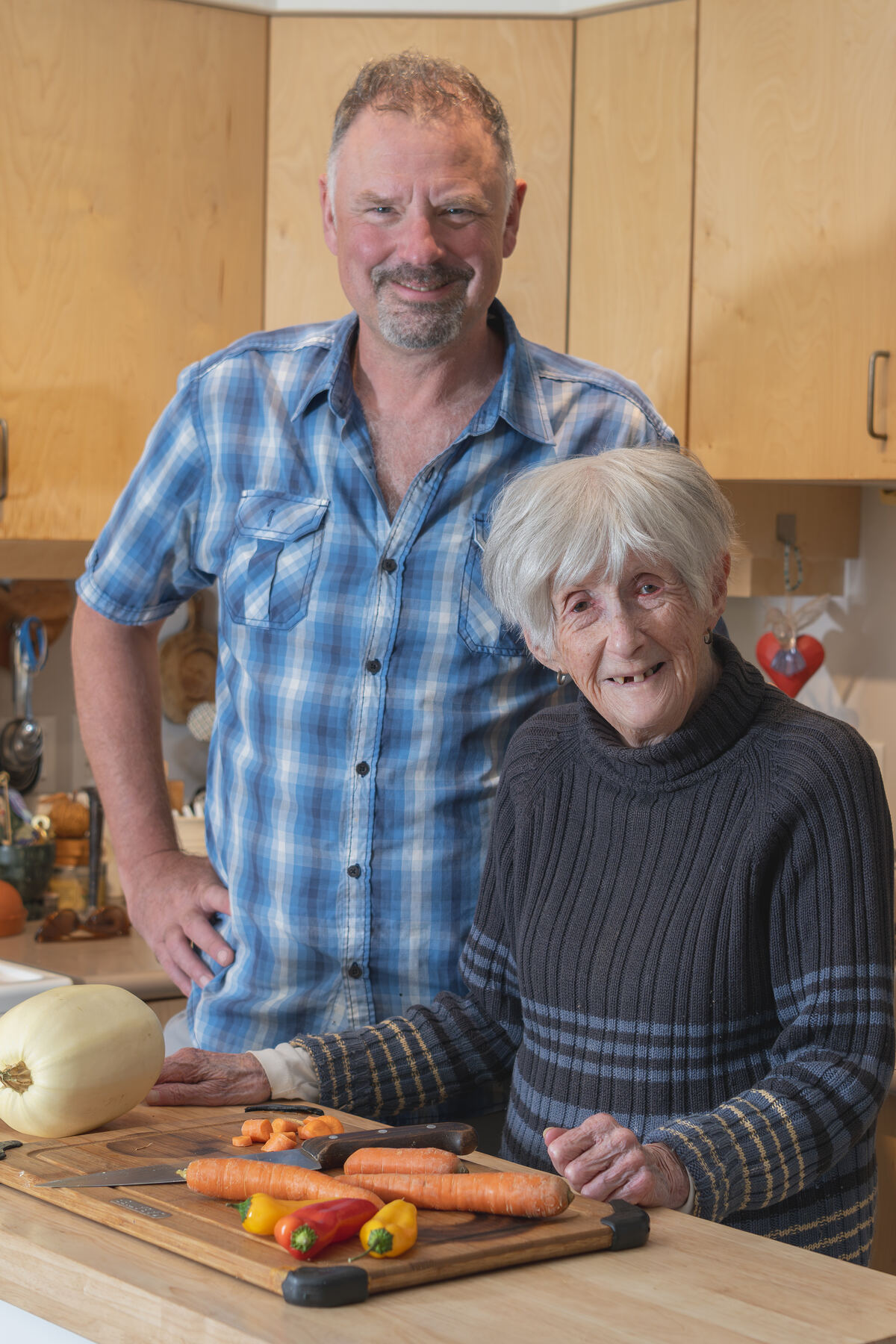 An Evergreen provider and a smiling client preparing vegetables in her kitchen